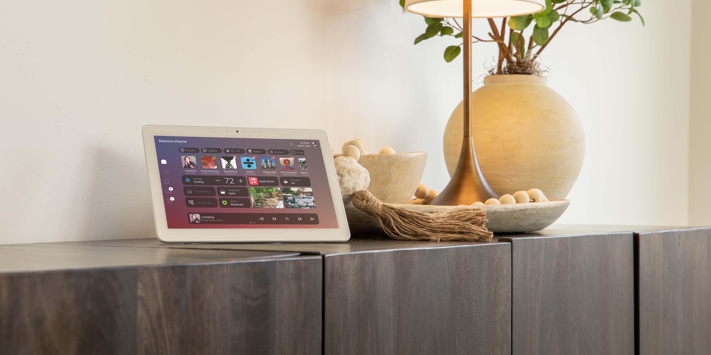 Control4 touch panel product in front of image of bedroom