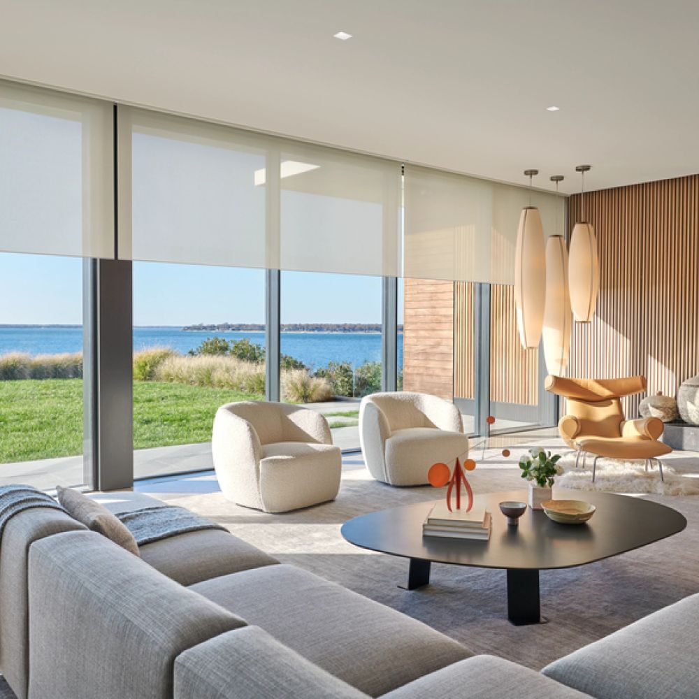 <span class="uk-h4">Lutron shades partially lowered on floor-to-ceiling windows in a luxury living room.</span>