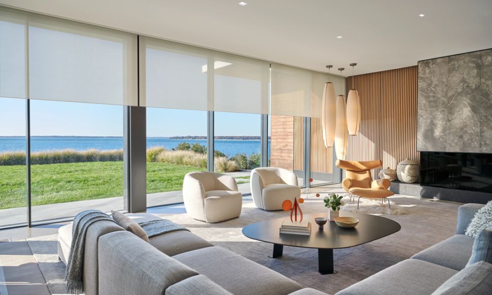 <span class="uk-h4">Lutron shades partially lowered on floor-to-ceiling windows in a luxury living room.</span>