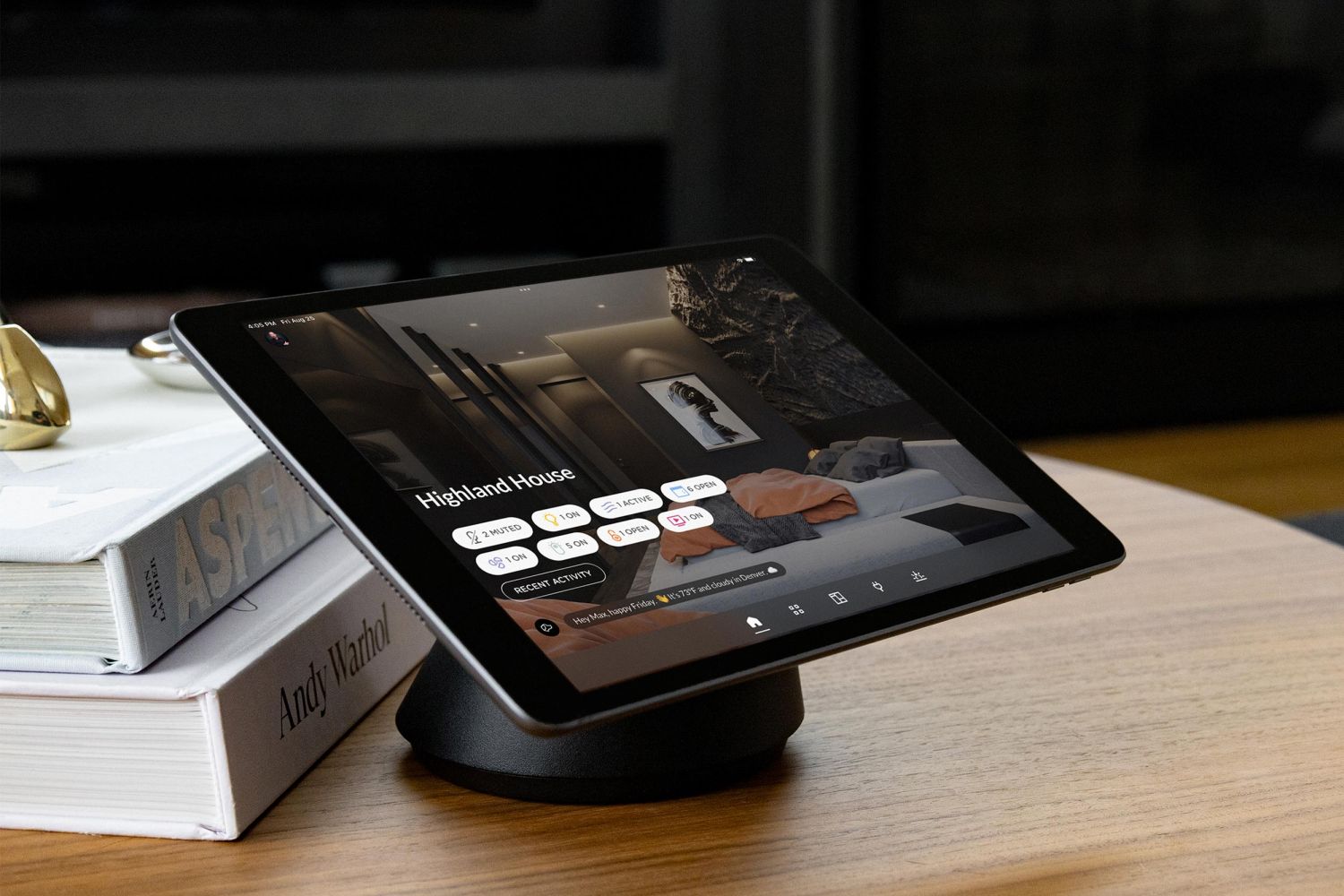 Tablet on a desk displaying a smart home control interface for lighting and rooms