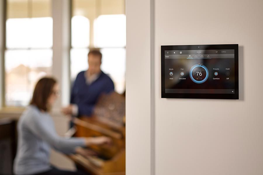 Wall-mounted smart thermostat interface showing temperature settings in a modern home.