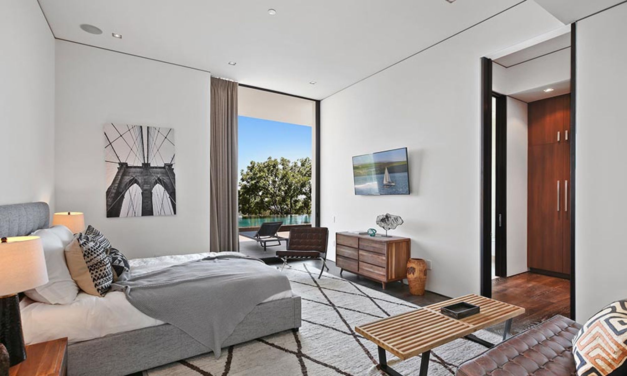 A cozy, contemporary bedroom with discreet in-ceiling speakers and stylish decor.