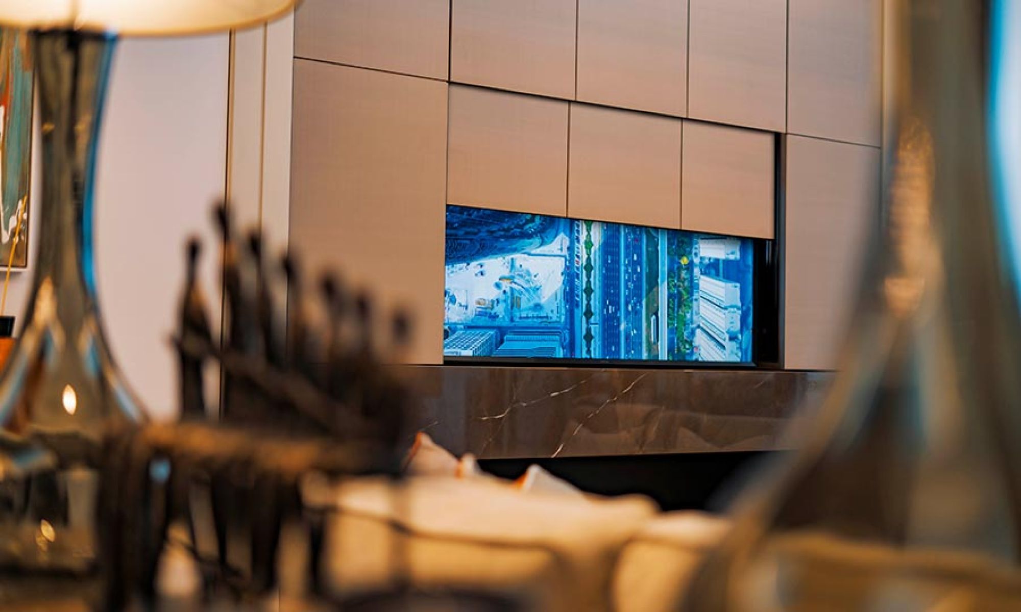 A hidden television emerging from a custom-built cabinet, framed by modern decor and soft lighting.