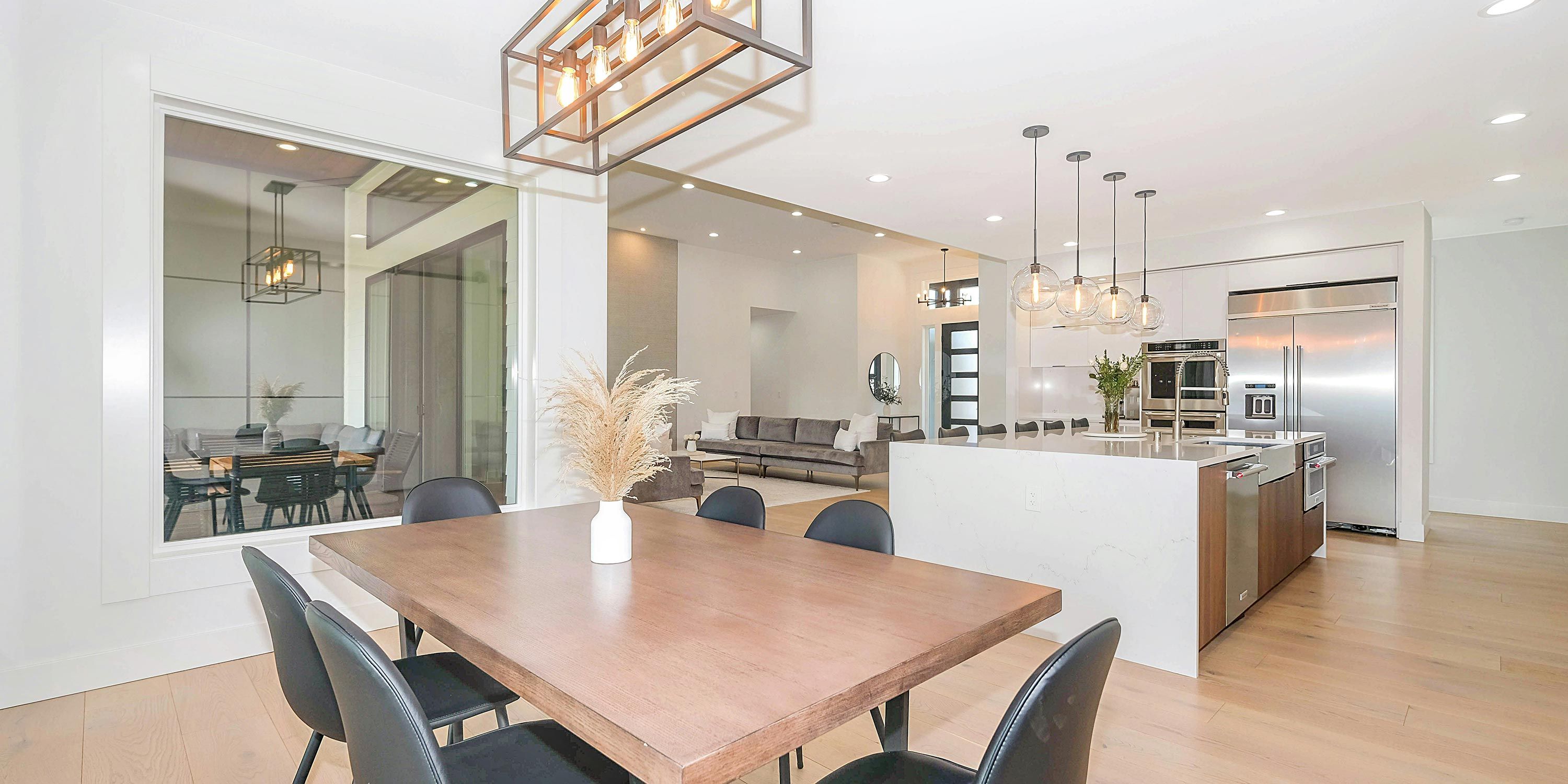 Contemporary open kitchen and dining area with sleek lighting and a spacious layout.