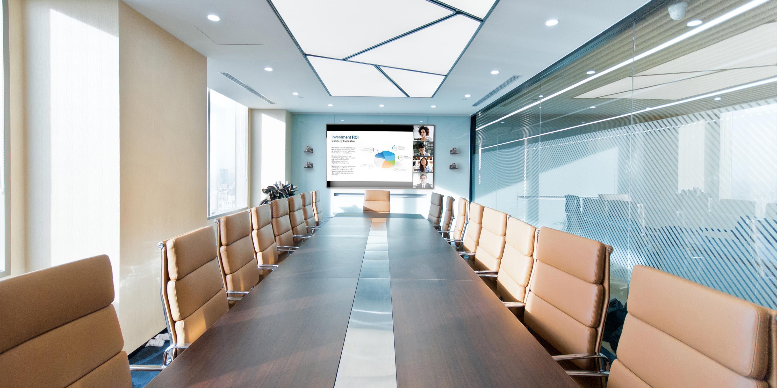 A sleek, professional conference room with a long table, tan leather chairs, and a presentation screen.