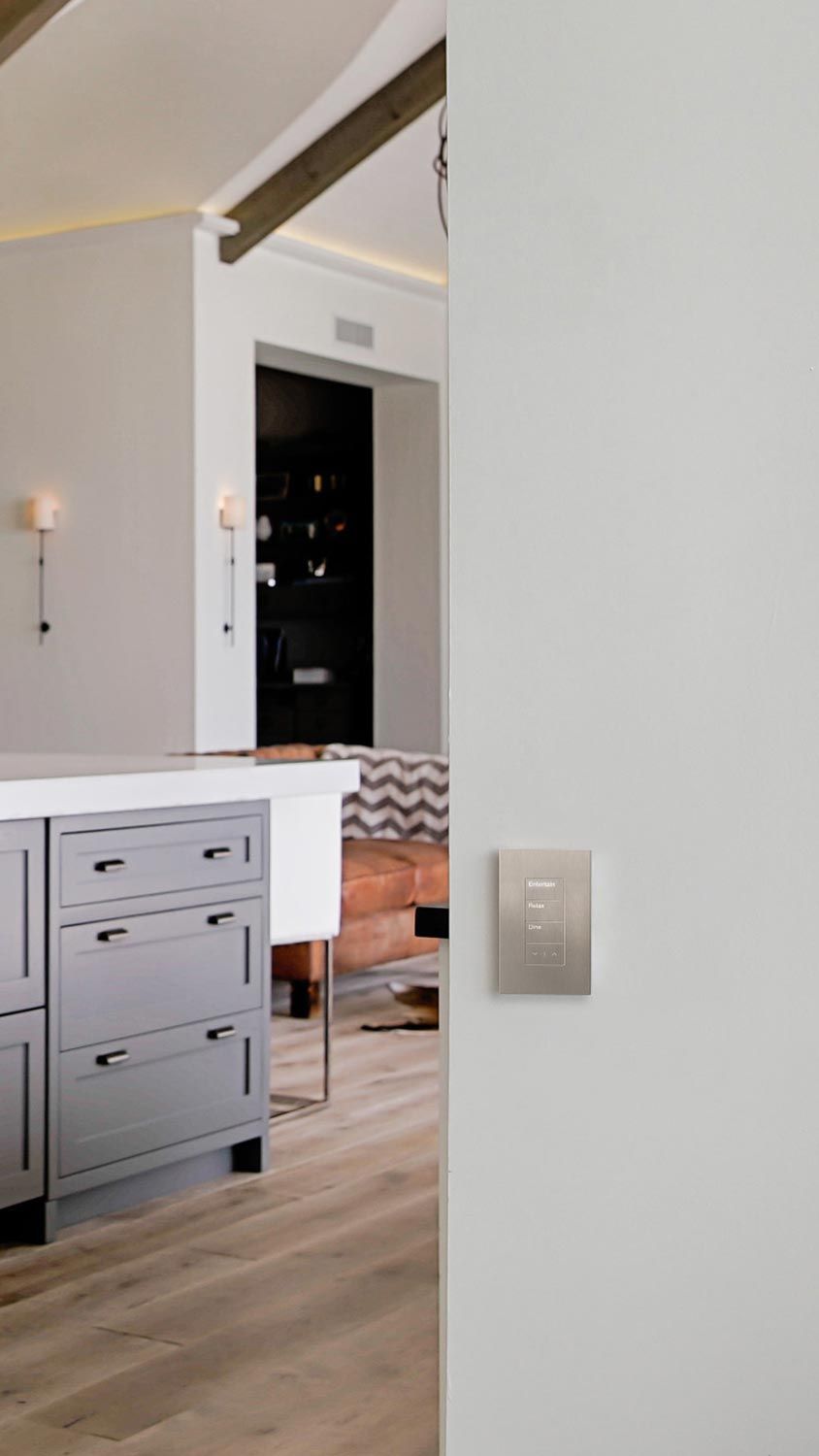 A sleek wall-mounted control panel for lighting and shading in a modern home interior.