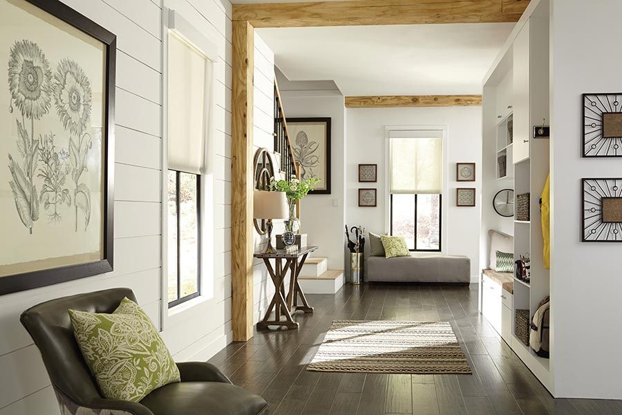 Cozy hallway with shiplap walls, rustic decor, and natural light streaming through windows.