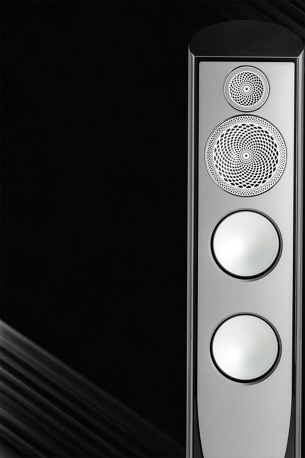 Close-up view of a high-fidelity speaker with intricate design details and a black backdrop.